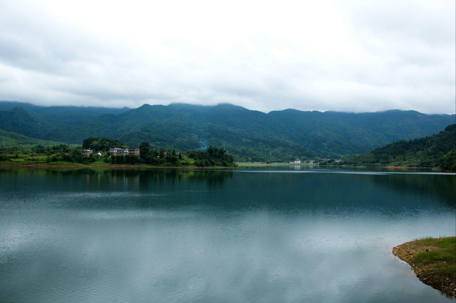 在水库的堤岸上遥望对岸的青山瓦房 周家水库