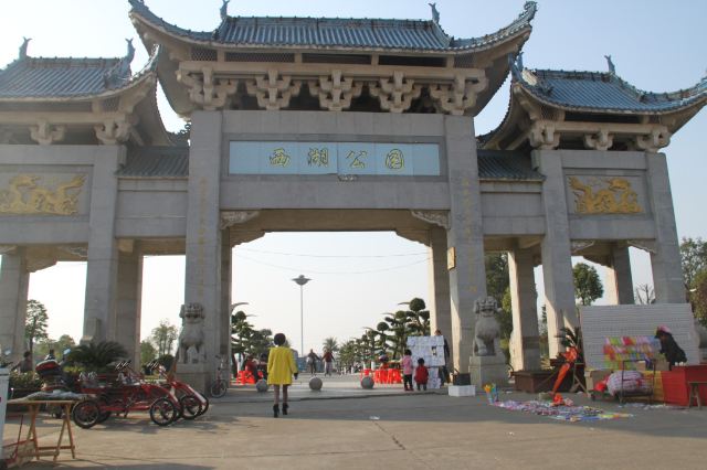 西湖公园  市民的休闲场所,草地上坐着晒太阳的民众.