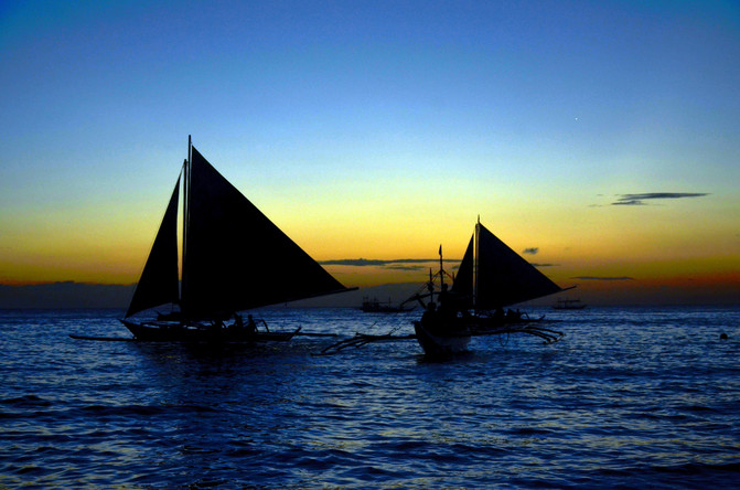 月亮從海上升起,彎彎的月牙遙掛空中,夕陽的餘暉印染的海面像戴上了金